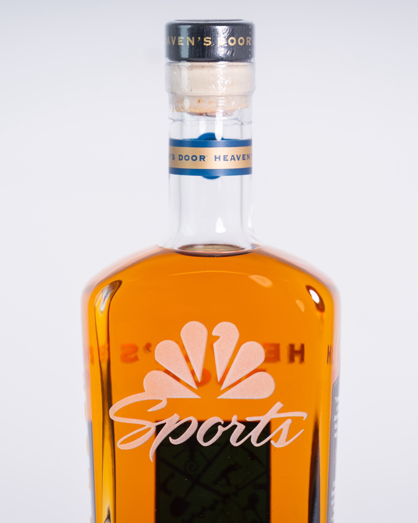 Heaven's Door bourbon bottle engraved with the NBC Sports peacock and Sports script, run of twenty-four.